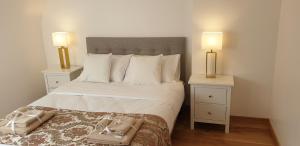 een slaapkamer met een groot bed met 2 nachtkastjes bij Crown Roads in Le Faouët