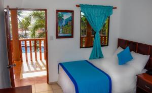 a bedroom with a bed with a window and a balcony at Mar & Sol, Hotel y resturante in La Unión