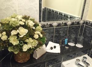 a bathroom with a vase of flowers next to a sink at Dublin Citi Hotel of Temple Bar in Dublin