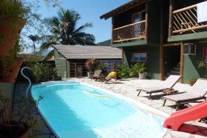 a swimming pool in front of a house at Pousada Três Marias Ilhabela in Ilhabela
