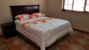 a bedroom with a large bed with flowers on it at Hornbills Rest Country Home in Phalaborwa