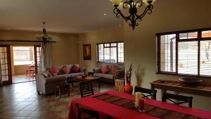 a living room with couches and a table and chairs at Hornbills Rest Country Home in Phalaborwa
