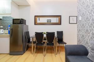 a dining room with a table and black chairs at Trees Residences SMDC by Jhoms in Manila