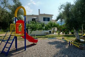 un parque infantil frente a una casa con tobogán en Riverside Αpartments, en Vasiliki
