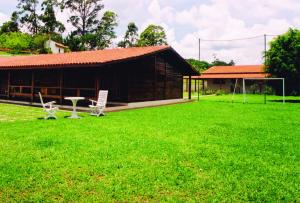 - un bâtiment avec deux chaises et une pelouse dans l'établissement CHACARA PRIMAVERAS, à Jarinu