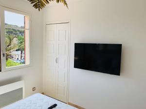 a living room with a flat screen tv on a wall at Maison en front de mer sur la plage de portissol in Sanary-sur-Mer