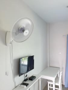 a room with a desk with a computer and a fan at Vanilla Ville Resort in Khlong Thom