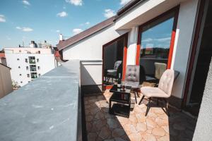 a balcony with two chairs and a table on a building at POINT flat, beautiful view from terrace to Prague Castle in Prague