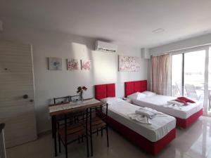 a hotel room with two beds and a table and a desk at Milla Lux 3 in Paralia Katerinis