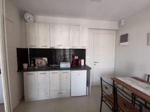 a kitchen with white cabinets and a clock on the wall at Milla Lux 3 in Paralia Katerinis