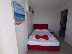 a bedroom with a bed with a red bow tie on it at Milla Lux 3 in Paralia Katerinis +15 photos