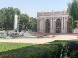 a building with a fountain in front of a building at Студия в центре Ташкента in Tashkent
