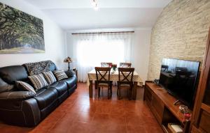 a living room with a black leather couch and a table at Casa Rural El Retiro de los Casasola in Establés