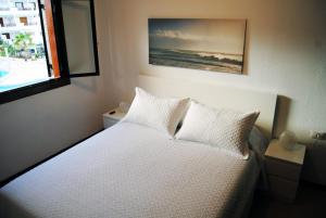 ロス・クリスティアーノスにあるOcean Light Apartment (100m from the beach)のベッドルーム1室(白いシーツ付きのベッド1台、窓付)
