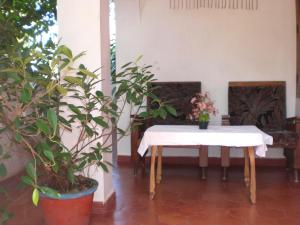 una mesa con un mantel blanco y plantas en Jickys Nest, en Varkala