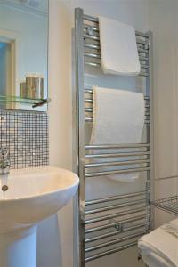 een badkamer met een wastafel en een handdoekenrek naast een spiegel bij Lundie View B & B in Invergarry