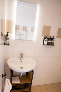 een badkamer met een wastafel en een spiegel bij De Jongens in Rockanje