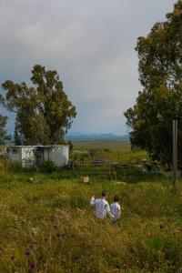 dos personas sentadas en un campo de hierba en NATURA-eco farm, en Natur