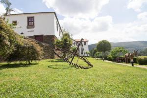 a horse is standing in the grass next to a house at Casa do Monte - Douro in Baião