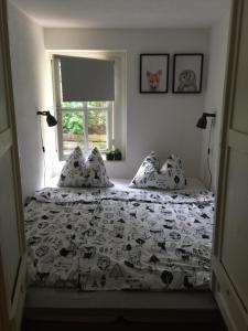 1 dormitorio con 1 cama con edredón blanco y negro en Loetje, en Gosau