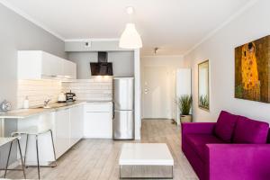 eine Küche und ein Wohnzimmer mit einem lila Sofa in der Unterkunft Super-Apartamenty Old Market in Posen