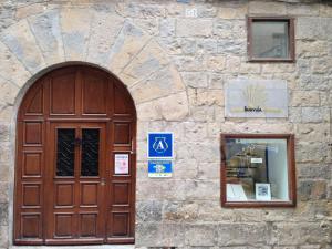 a wooden door on a stone building with a window at Hostel Casa Ibarrola in Pamplona