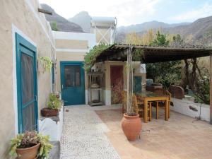 une terrasse avec une porte bleue et une table ornée de plantes dans l'établissement Encantadora Casa con piscina privada en el Risco de Agaete, à Agaete