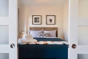ein Schlafzimmer mit einem blauen Bett mit zwei Bildern an der Wand in der Unterkunft INITIAL - MAITRE - Chutes-Montmorency in Boischâtel