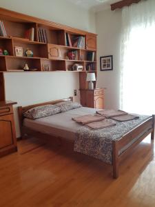 a bedroom with a large bed with wooden shelves at FAMILY APARTMENT Meteora in Kalabaka