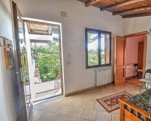 um quarto com uma grande janela e uma porta para uma varanda em Casavacanzeinsicilia Etna Taormina em Piedimonte Etneo