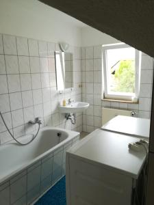 a white bathroom with a tub and a sink at Kunstgasse 11, Wohnung 10 in Altenburg
