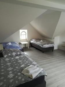 a attic bedroom with two beds and a window at Kunstgasse 11, Wohnung 10 in Altenburg
