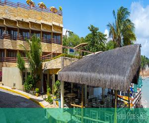 a hotel with a thatch roof next to a swimming pool at Sonia Flats Pipa's Bay - Flat 211 in Pipa