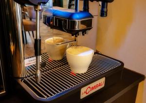 eine Kaffeemaschine mit zwei Tassen auf der Theke in der Unterkunft Hotel Zuckerfabrik in Stuttgart