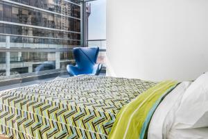 a bedroom with a bed and a blue chair at Breathtaking Apartment City Center - PH Quartier Atlapa in Panama City +25 photos