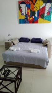 a bedroom with a bed with a painting on the wall at Imóvel na Beira-Mar in Pipa