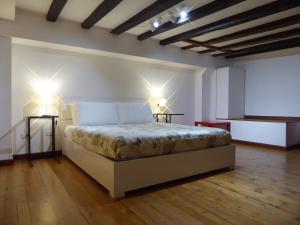 una camera da letto con un letto con due luci sopra di Giudei House Suite Bologna a Bologna