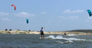 Dos personas están haciendo kitesurf en el agua en Coliseu Piazza em frente o aterro, en Fortaleza