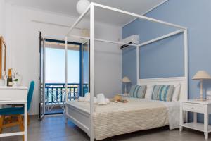a bedroom with a white canopy bed with a view of the ocean at Meltemi Studios in Megalochori
