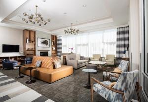 a living room with a couch and chairs at Pomeroy Hotel Fort McMurray in Fort McMurray