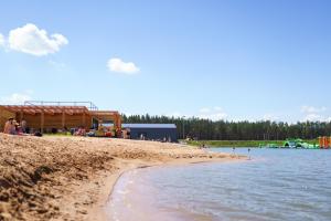 a group of people on a beach next to the water at Raceway Baltic cabins in Silakrogs