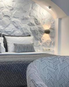 een slaapkamer met een bed en een stenen muur bij Marina's Suites in Naxos Chora