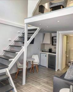 a living room with a staircase and a kitchen at Marina's Suites in Naxos Chora