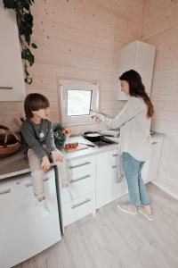 a woman and a child in a small kitchen at 333 CAMPING PARK in Silakrogs +33 photos