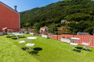 - un ensemble de tables et de chaises sur un balcon avec une montagne dans l'établissement Mira Vietri, à Vietri