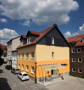 a large yellow building with a black roof at Hotel Garni Am Kirchplatz in Ilmenau