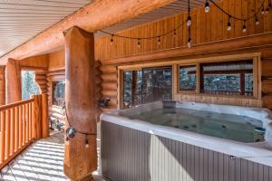 bañera de hidromasaje en la cubierta de una cabaña de madera en Spirit Lodge at Silverstar, en Vernon