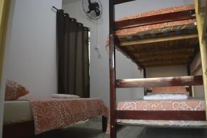 a room with two bunk beds and a bed and a chair at Apartamento para 7 pessoas próximo a Basílica in Aparecida
