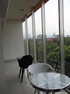 una mesa y sillas frente a una gran ventana en Hotel Quinta Tlalpan en Ciudad de México