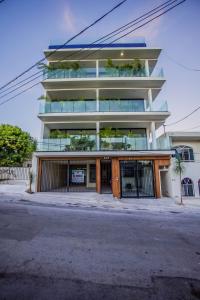een hoog gebouw met een hek ervoor bij Family Apartments Near Beach Polo88 in Playa del Carmen